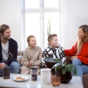 Eine Frau und ein Mann mit zwei Kindern sitzen auf einem Sofa