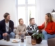 Eine Frau und ein Mann mit zwei Kindern sitzen auf einem Sofa