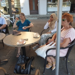 Sprachtreff Eisessen 7_2026 Drei Damen, eine mit Kopftuch sitzen in einer Eisdiele am Tisch