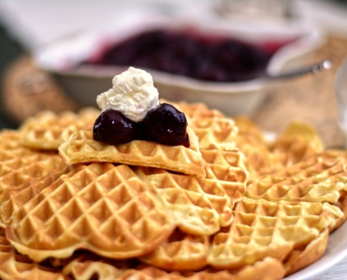 Waffeln mit Marmelade und Sahne auf Teller
