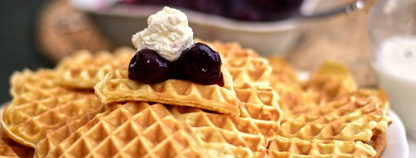 Waffeln mit Marmelade und Sahne auf Teller