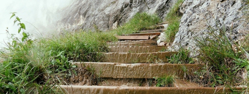 Holzstufen im Gebirge hin zu einem Fels