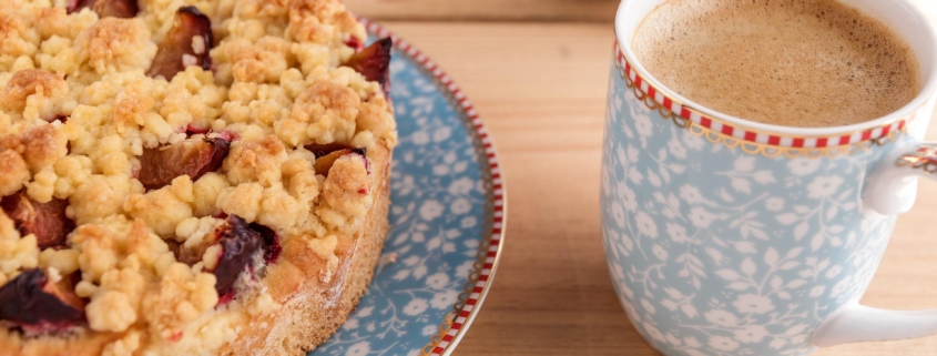 Kaffeetasse mit Kaffe und Zwetschgenkuchen